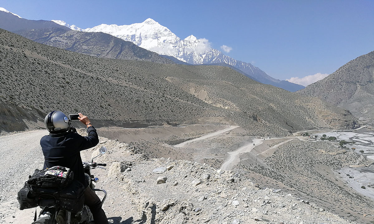 A rider from France takes a picture of Mt. Nilgiri on the way back.